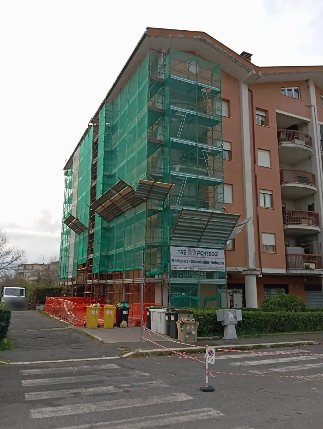 Condominio di sette piani con ponteggio a telaio su tutta la facciata, reti e mantovane parasassi